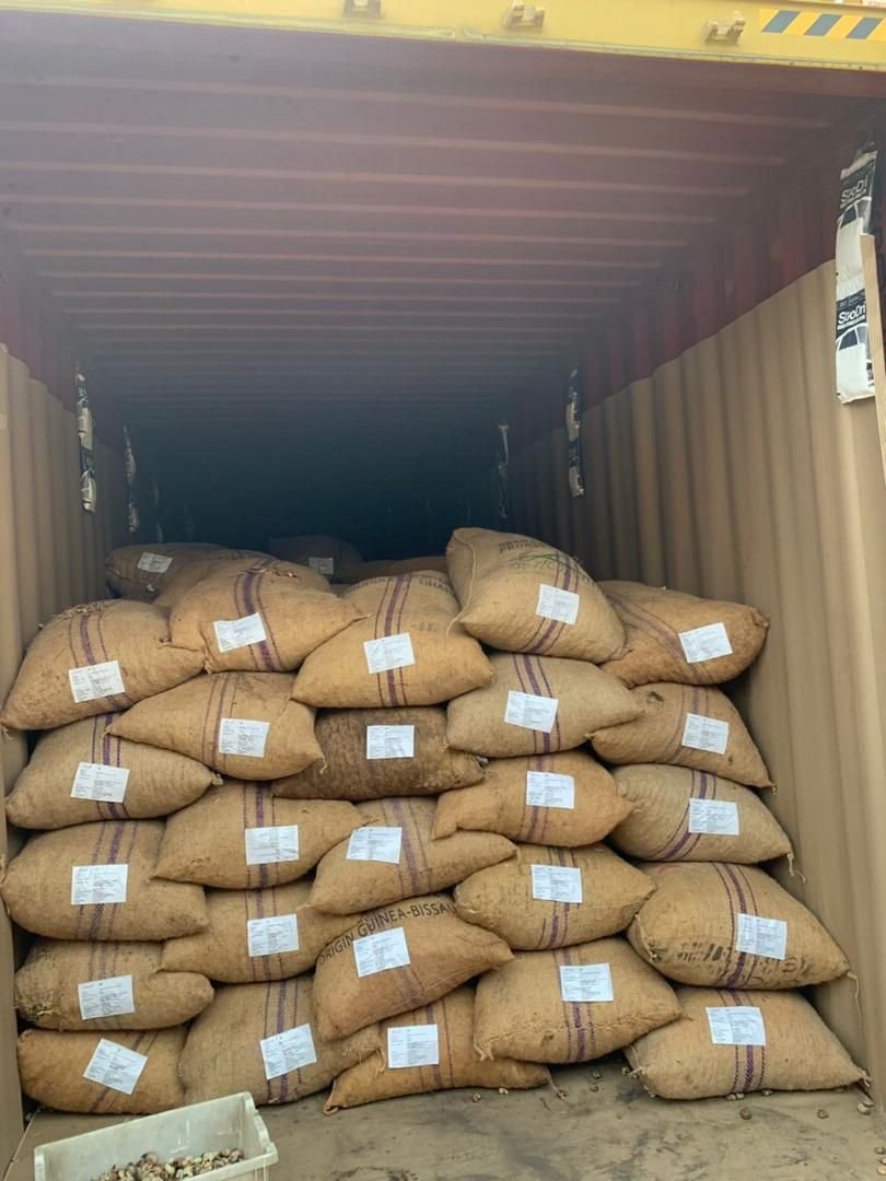 Jute sacks of raw cashew nuts packed tightly inside a container