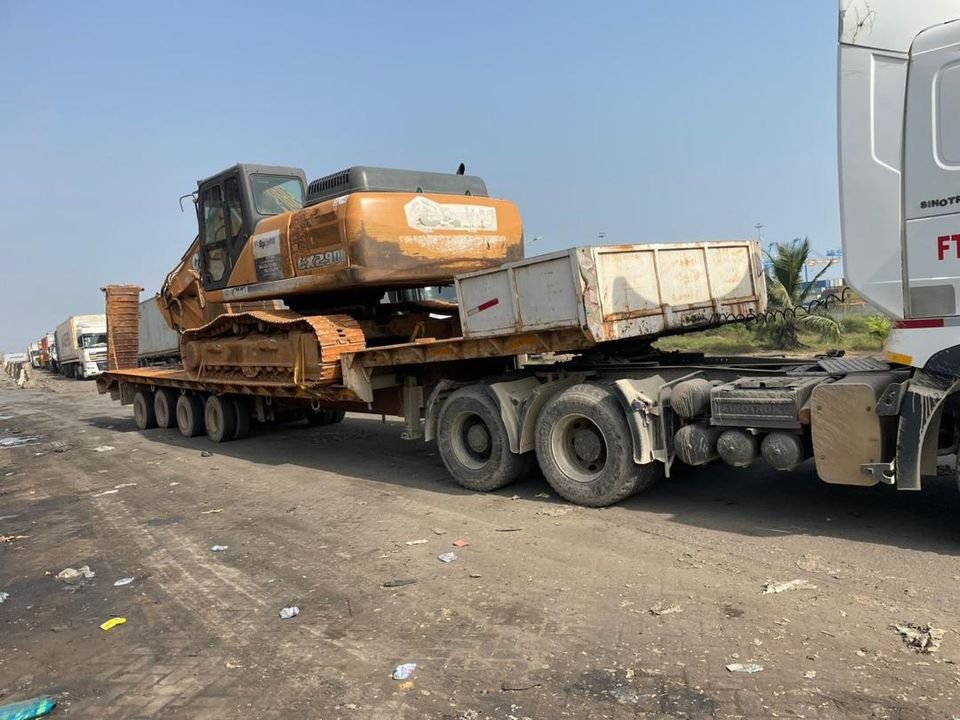 Excavator secured on a lowbed trailer in a truck yard